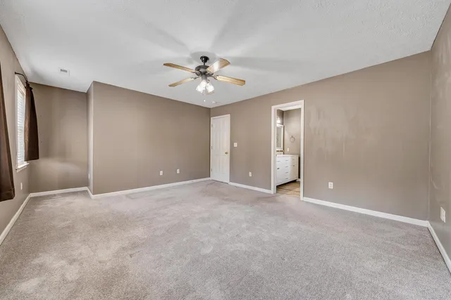 a view of an empty room with a ceiling fan