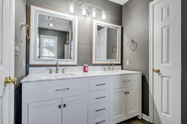 a bathroom with a granite countertop sink double and mirror