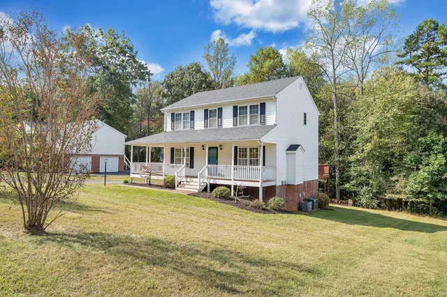 a front view of a house with a garden and trees
