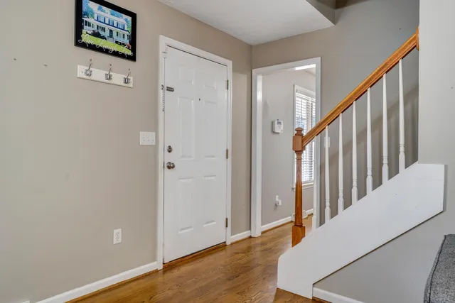 a view of a hallway with wooden floor and staircase