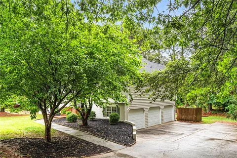a view of a house with backyard and tree