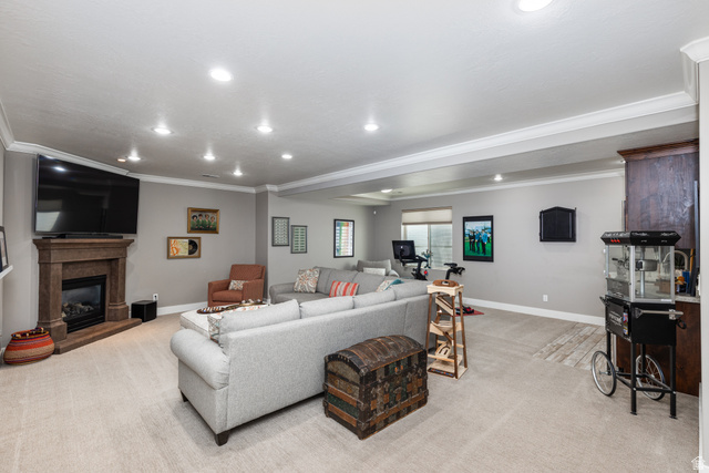 1132 Sunset Dunes Way Draper, UT 84020 - Photo 22 of 35 Spacious lower-level living area featuring recessed lighting, crown molding, and a corner fireplace with a stone surround
