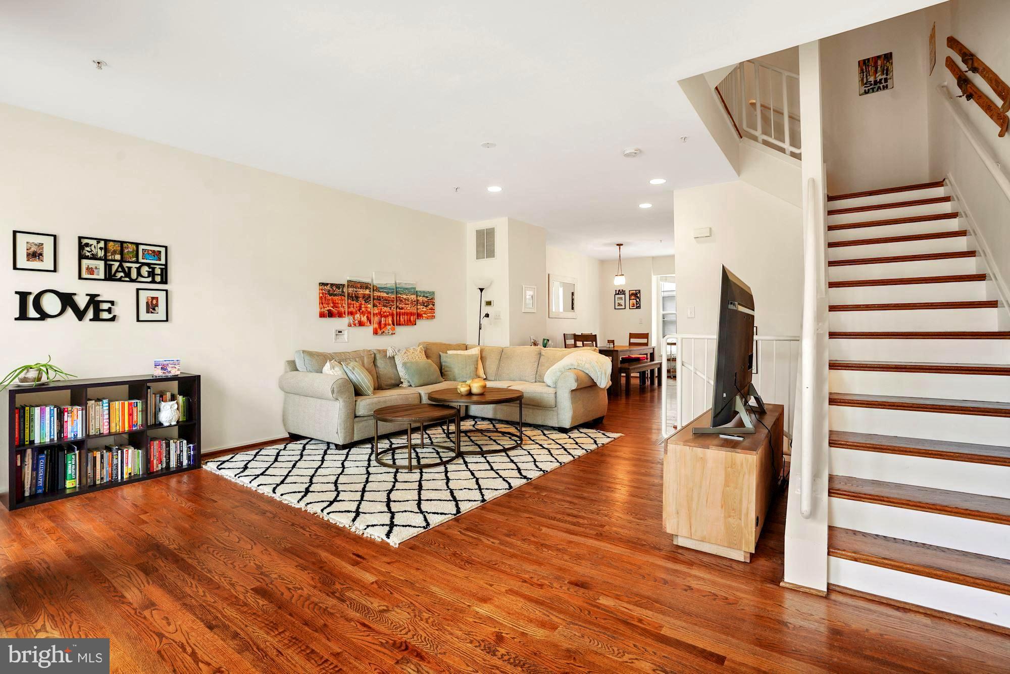 a living room with furniture and a wooden floor