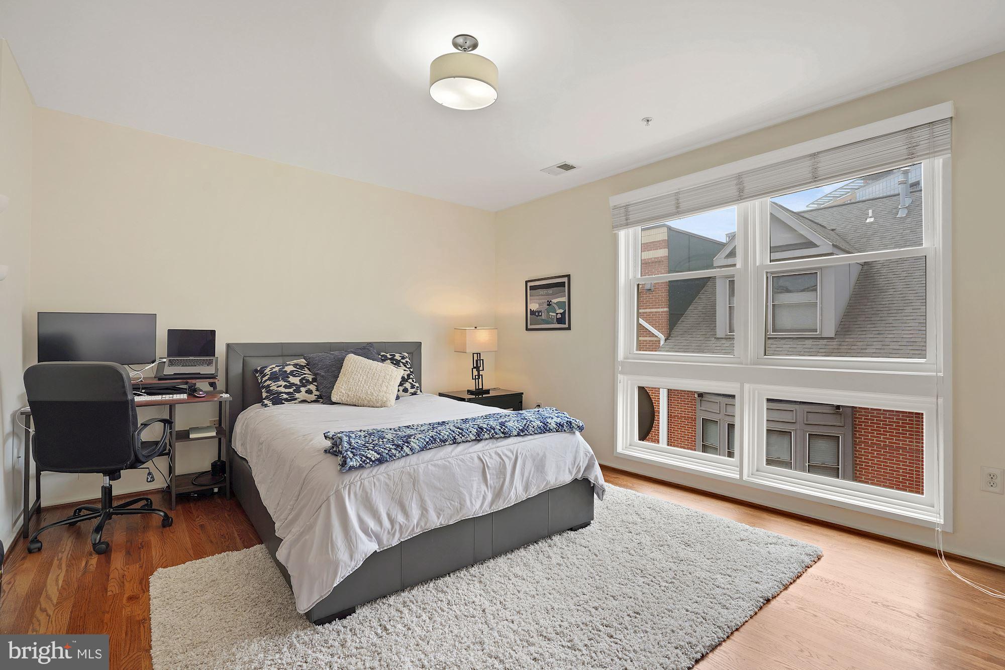 1618 North Rhodes Street Arlington, VA 22209 - Photo 23 of 33 a bedroom with a bed and wooden floor