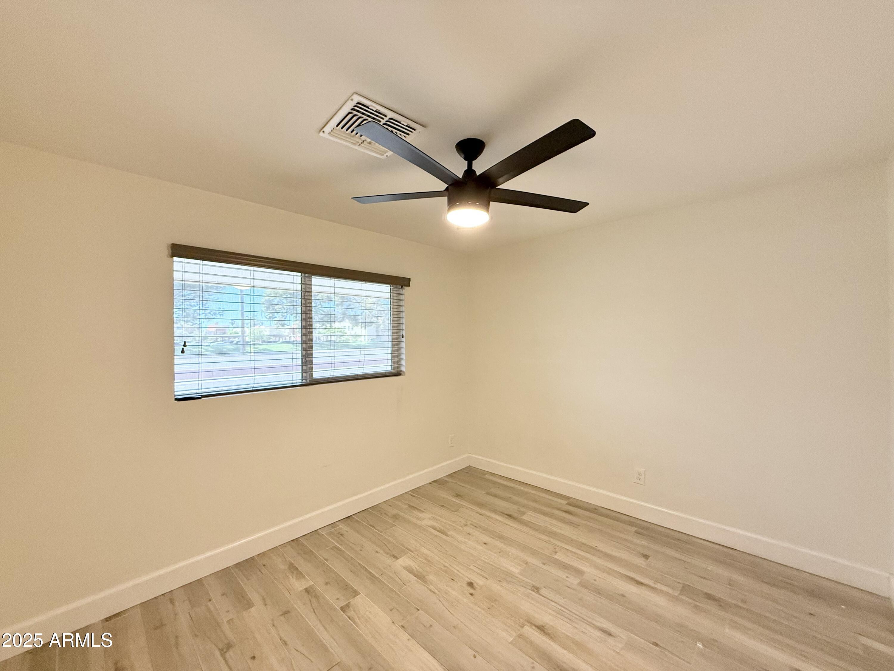 3625 North Hayden Road Scottsdale, AZ 85251 - Photo 13 of 24 an empty room with wooden floor and ceiling fan