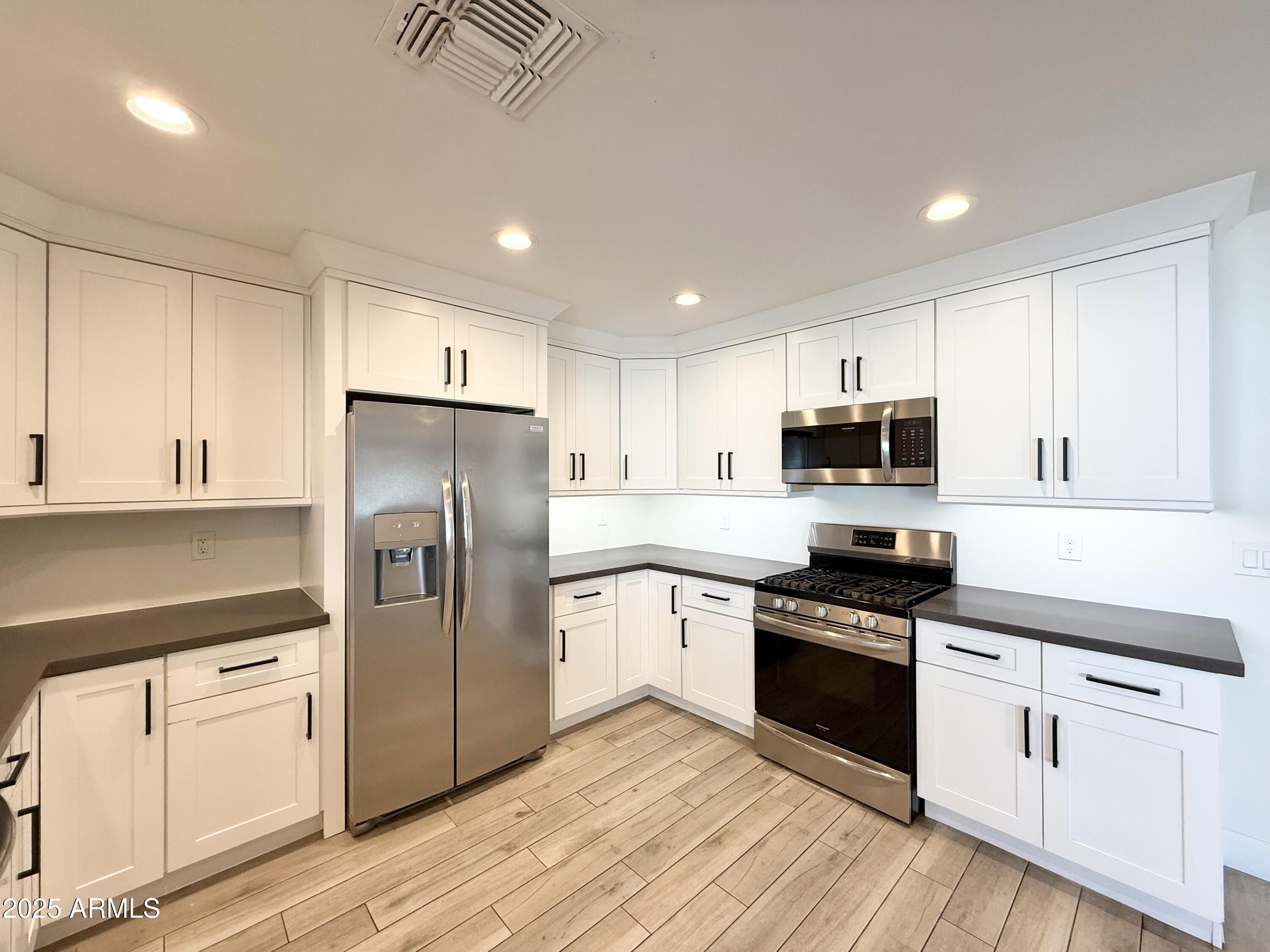 3625 North Hayden Road Scottsdale, AZ 85251 - Photo 4 of 24 a kitchen with granite countertop white cabinets and stainless steel appliances