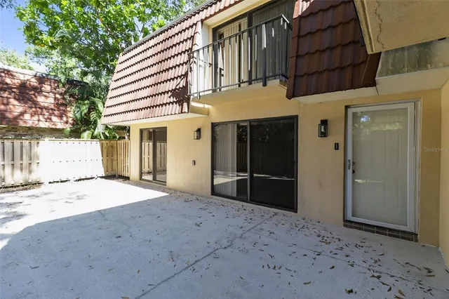 a view of backyard with wooden fence and a large tree