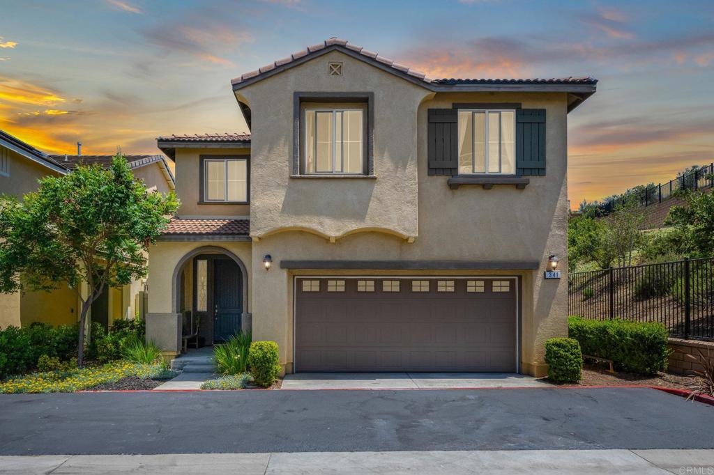 a front view of a house with yard and parking