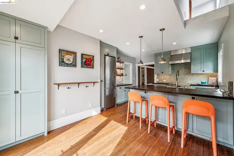 a kitchen with stainless steel appliances granite countertop a refrigerator a sink and a stove