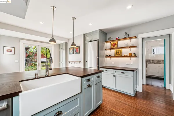 a kitchen with stainless steel appliances a sink a stove and a wooden floor