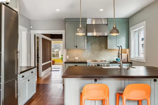 a kitchen with stainless steel appliances granite countertop a table chairs in it and wooden floors