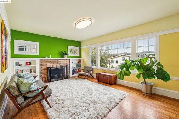 a living room with furniture a fireplace and a potted plant