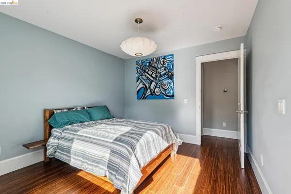 a bedroom with a bed and wooden floor