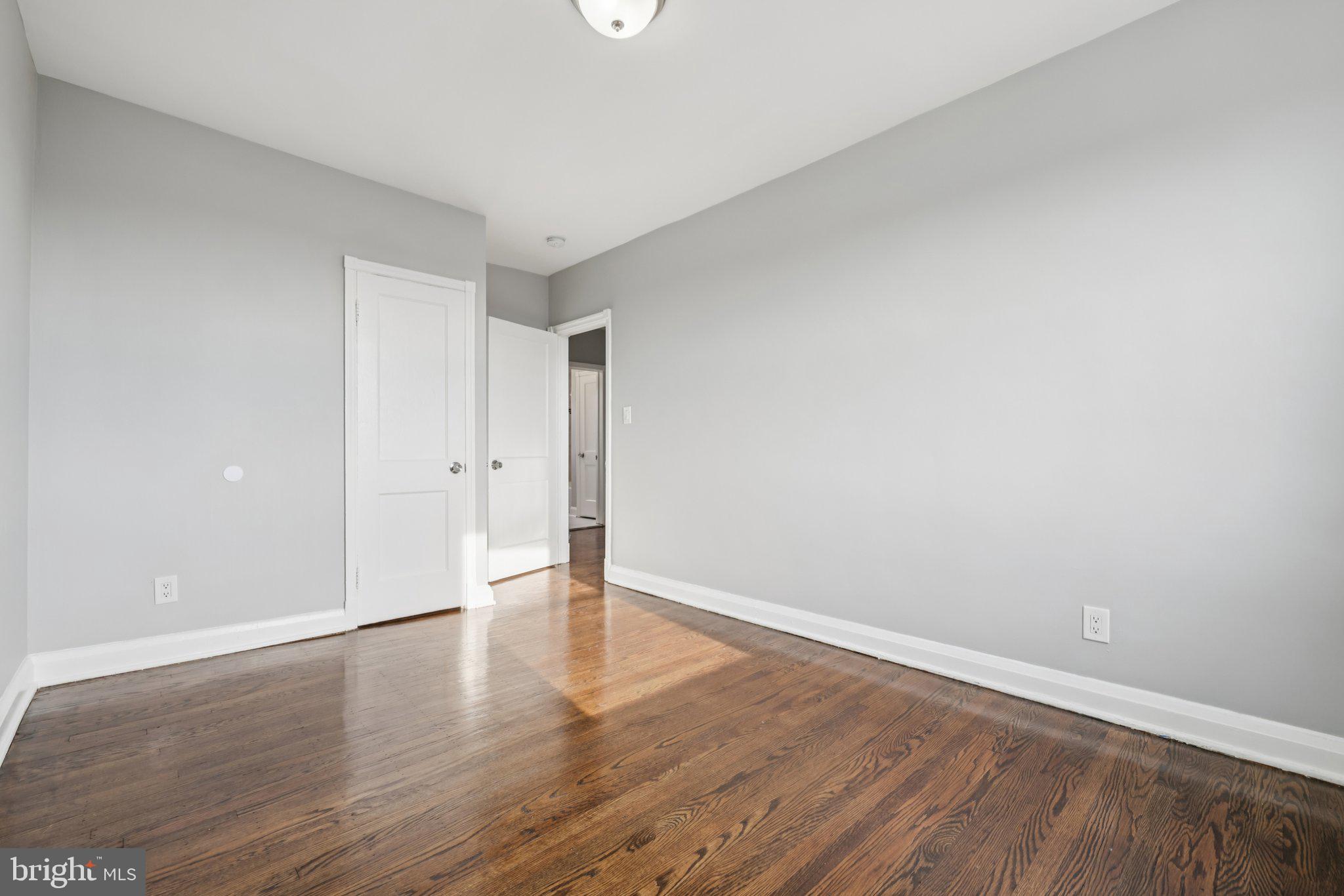 3427 Woodstock Avenue Baltimore, MD 21213 - Photo 22 of 46 a view of an empty room with wooden floor