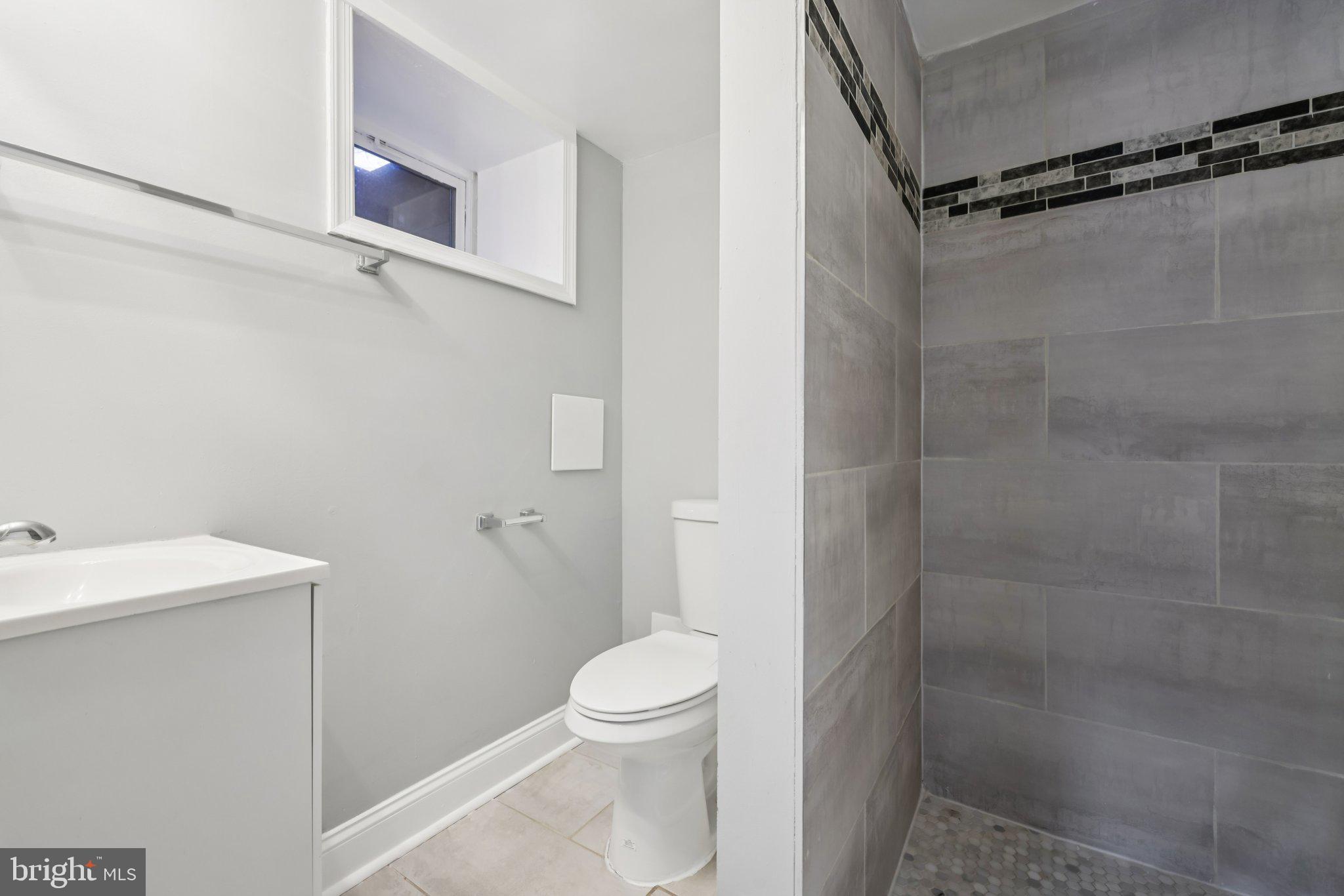 3427 Woodstock Avenue Baltimore, MD 21213 - Photo 29 of 46 a bathroom with a shower a toilet and a sink
