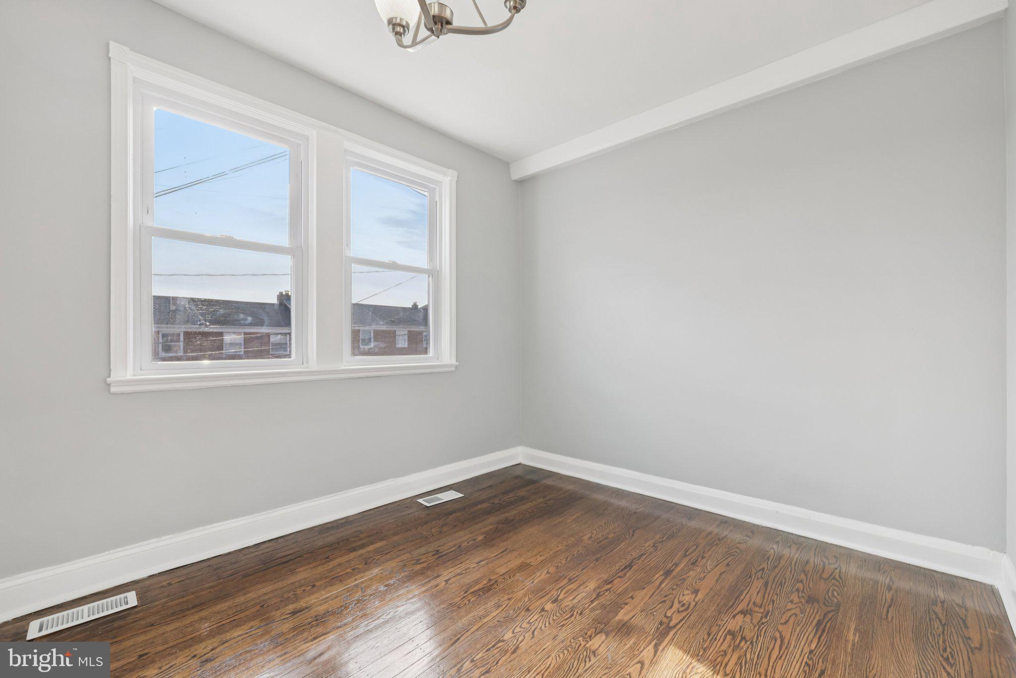 3427 Woodstock Avenue Baltimore, MD 21213 - Photo 32 of 46 a view of a room with wooden floor and windows