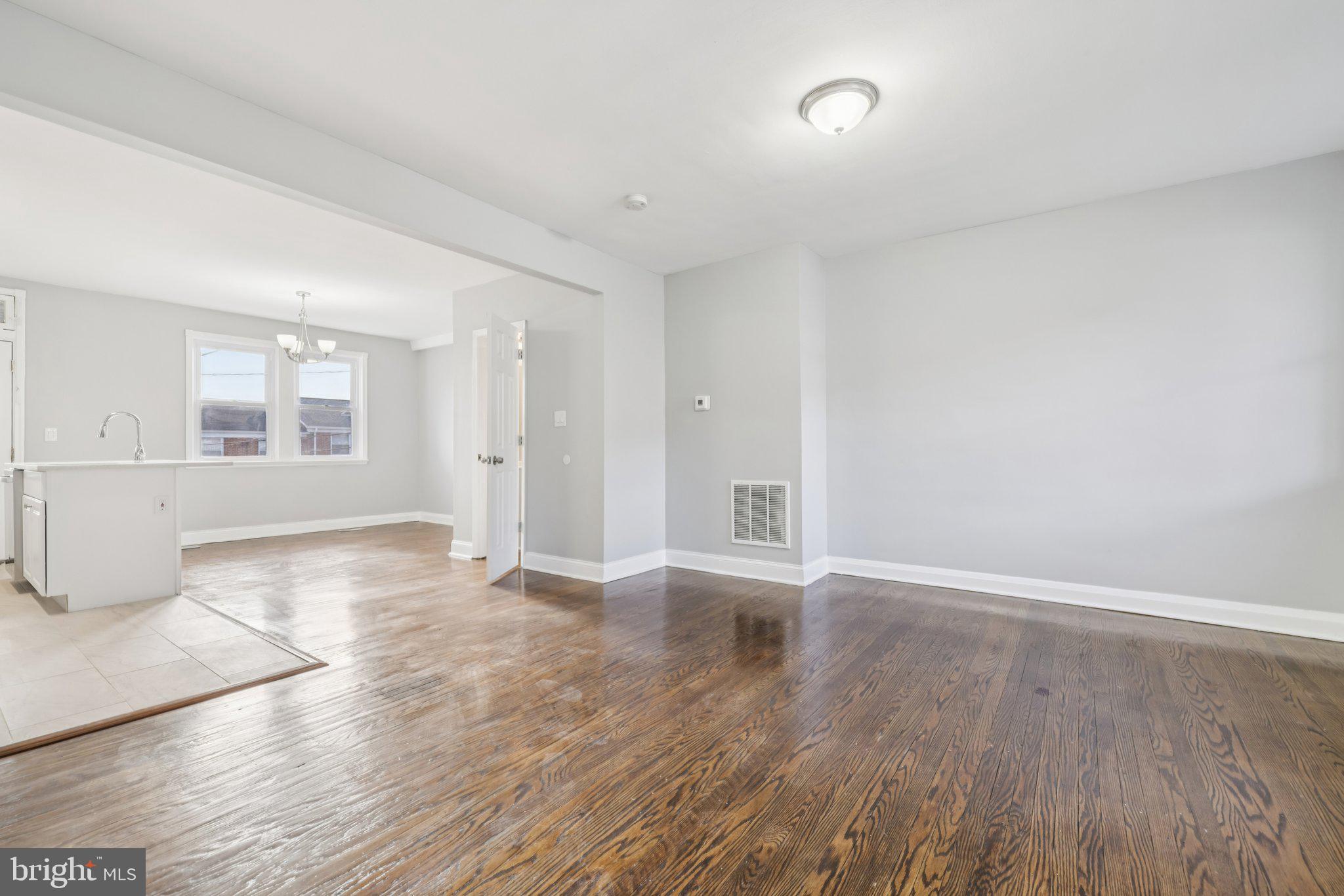 3427 Woodstock Avenue Baltimore, MD 21213 - Photo 8 of 46 an empty room with wooden floor and windows