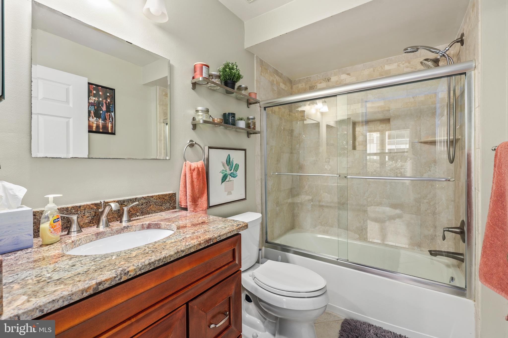 14197 Cuddy Loop, Unit 104 Woodbridge, VA 22193 - Photo 17 of 33 a bathroom with a granite countertop sink toilet and shower