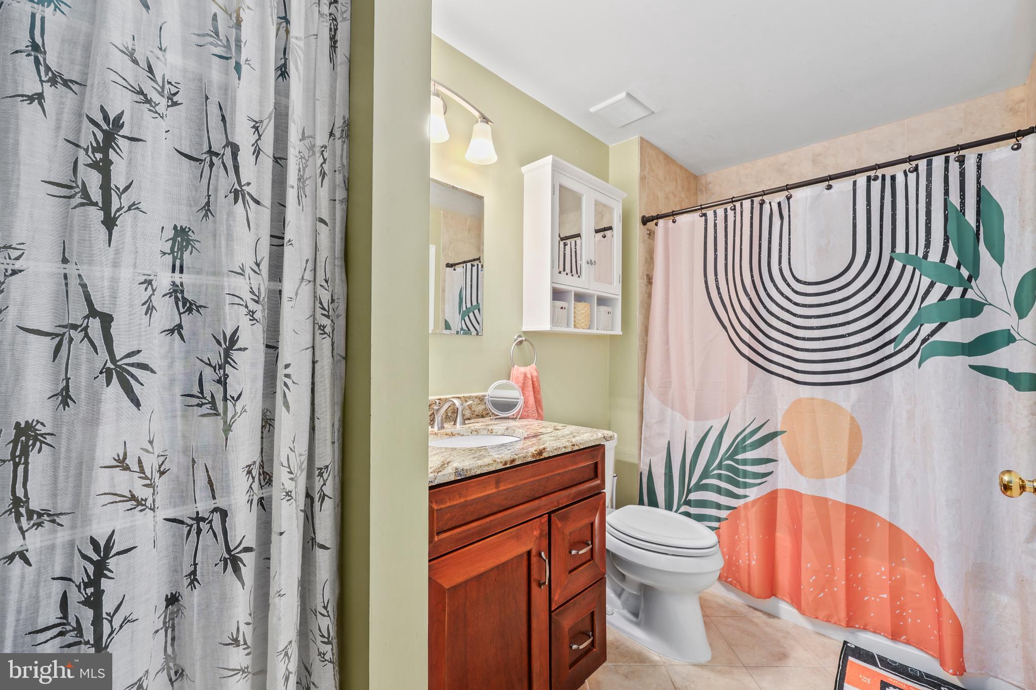 14197 Cuddy Loop, Unit 104 Woodbridge, VA 22193 - Photo 23 of 33 a bathroom with a sink a toilet and shower curtain