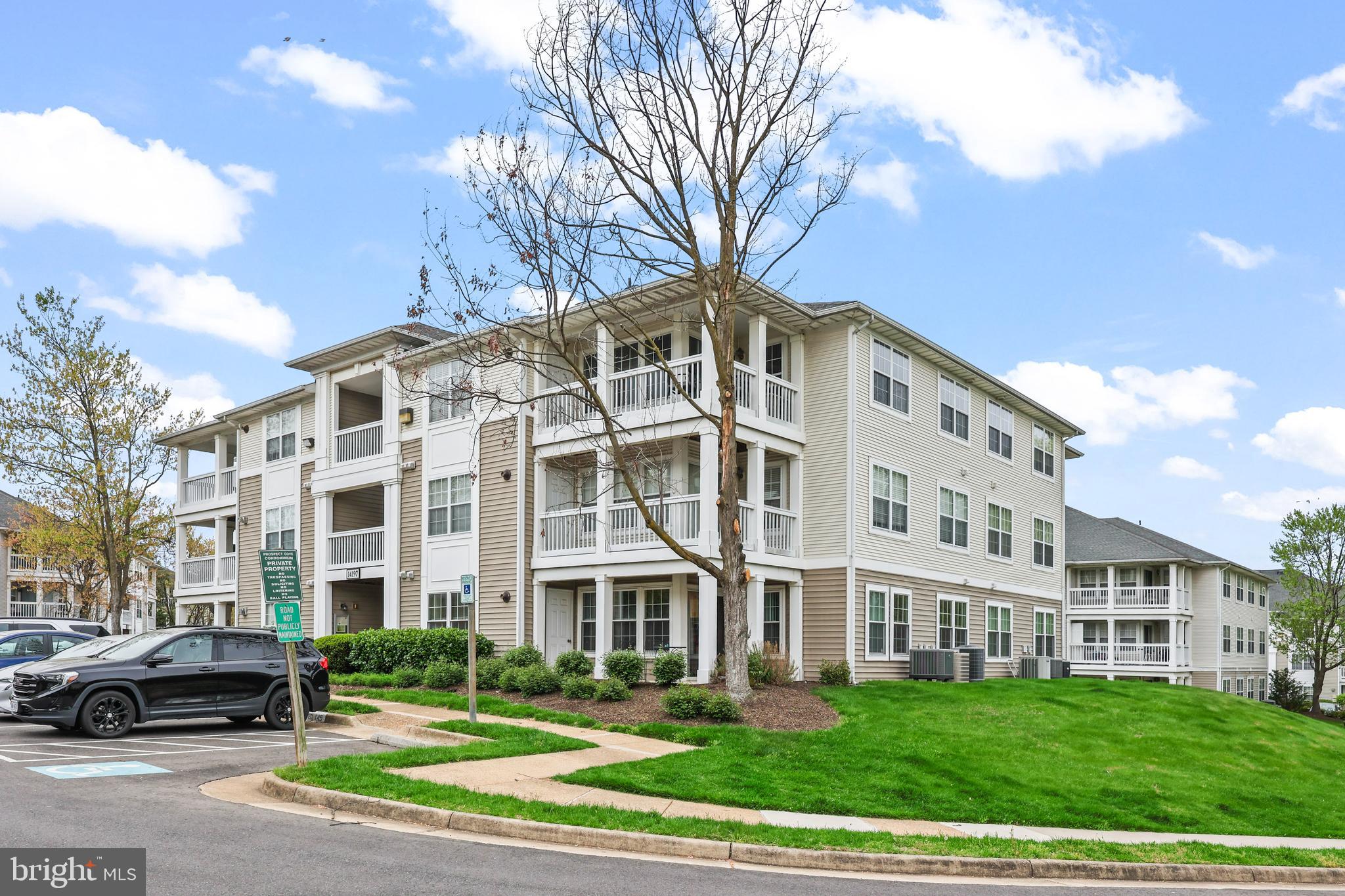 14197 Cuddy Loop, Unit 104 Woodbridge, VA 22193 - Photo 3 of 33 a front view of a building with lot of cars and trees