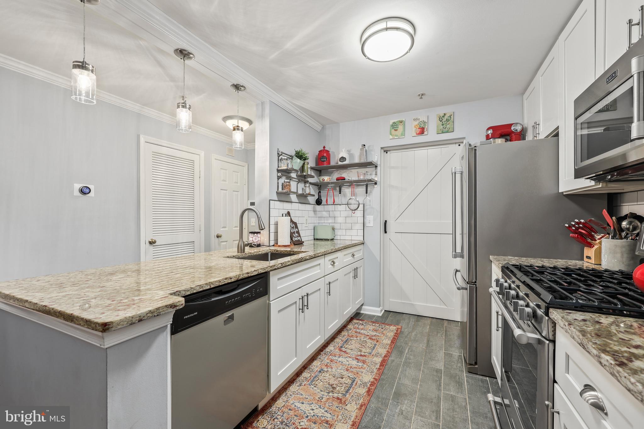 14197 Cuddy Loop, Unit 104 Woodbridge, VA 22193 - Photo 6 of 33 a kitchen with granite countertop a sink stove and refrigerator