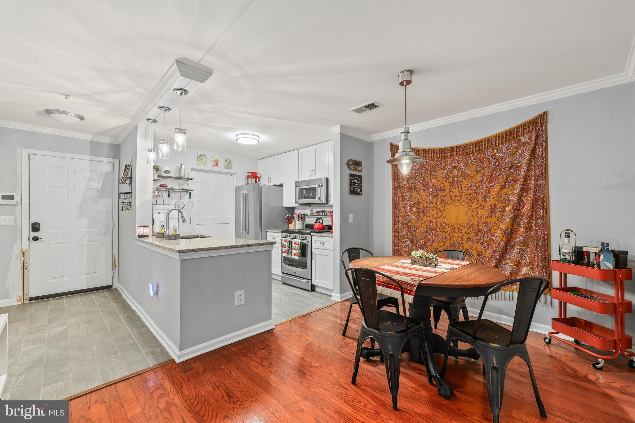 14197 Cuddy Loop, Unit 104 Woodbridge, VA 22193 - Photo 8 of 33 a kitchen with stainless steel appliances a dining table chairs and wooden floor