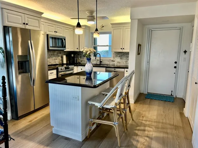 a kitchen with stainless steel appliances granite countertop a sink and a stove