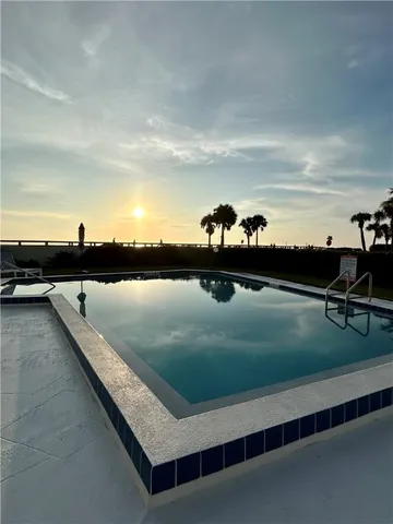 a view of swimming pool with outdoor seating and plants
