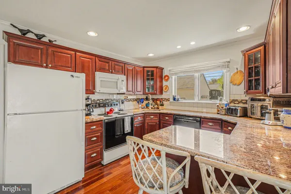 a kitchen with stainless steel appliances granite countertop a refrigerator a stove a sink and a microwave