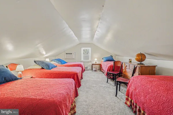 a bedroom with three beds and chair