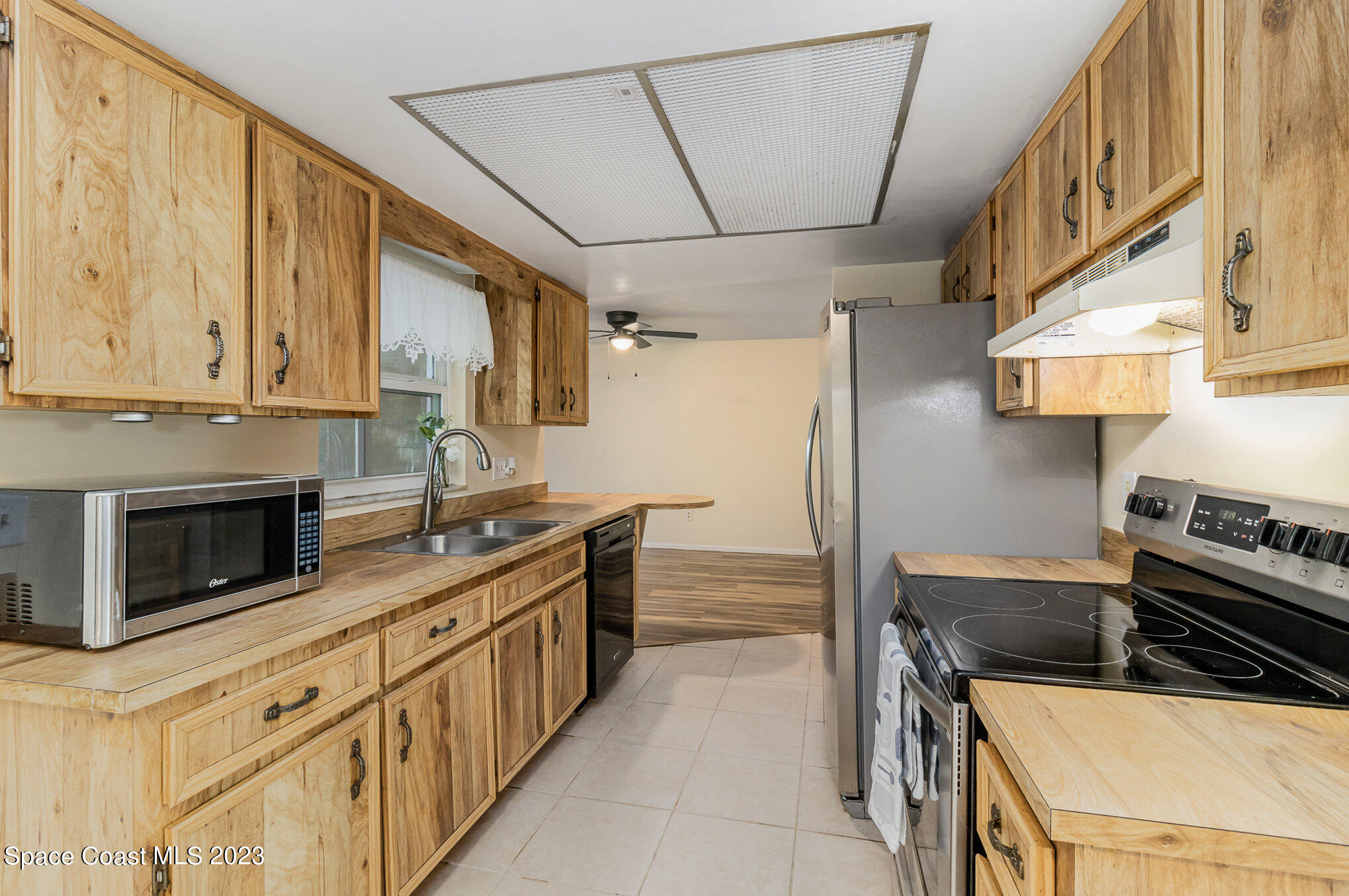 649 Croton Road Melbourne, FL 32935 - Photo 9 of 22 a kitchen with stainless steel appliances granite countertop a stove a sink and a microwave