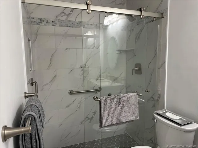 a bathroom with a shower a toilet and sink