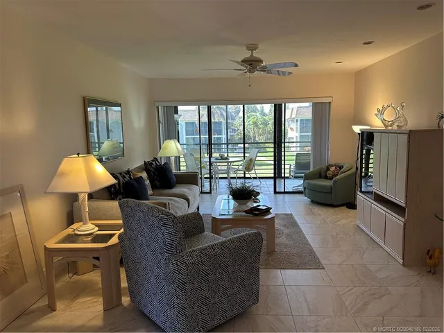 a living room with furniture a lamp and a large window