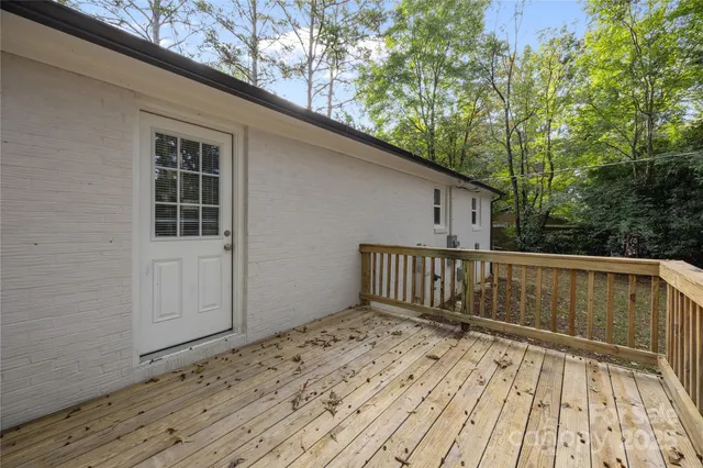 a view of a wooden house with a yard and large tree