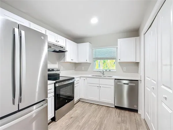 a kitchen with stainless steel appliances a stove a sink and a refrigerator