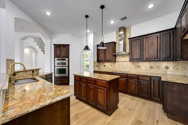 a kitchen with stainless steel appliances granite countertop wooden cabinets sink and stove