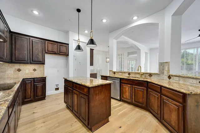 a large kitchen with stainless steel appliances granite countertop a sink stove and refrigerator