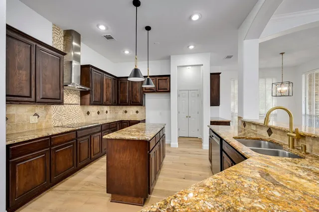 a kitchen with stainless steel appliances granite countertop wooden cabinets a sink and a stove