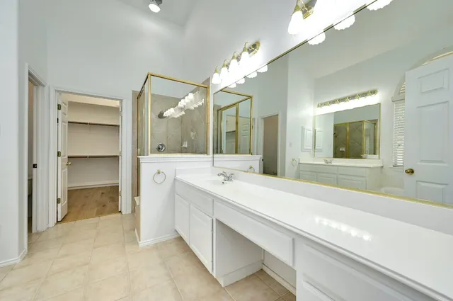 a spacious bathroom with a sink a large mirror and a shower