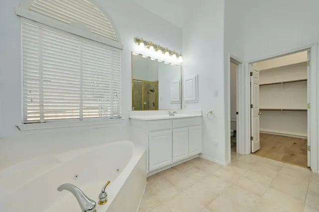 a bathroom with a tub sink and mirror