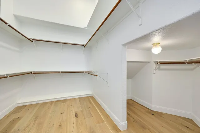 a view of walk in closet with empty racks