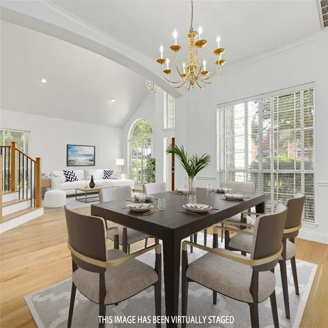 a view of a dining room with furniture a chandelier and wooden floor