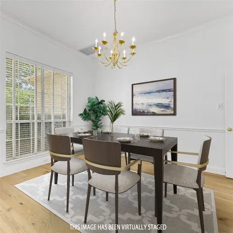 a dining room with furniture a rug and a potted plant