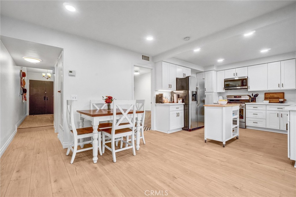 1514 Via Del Rio Corona, CA 92882 - Photo 10 of 41 a dining room with stainless steel appliances kitchen island granite countertop a table chairs and a refrigerator
