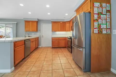 a kitchen with stainless steel appliances granite countertop a refrigerator and a sink