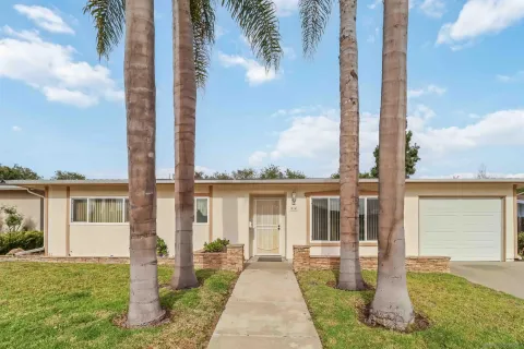 a front view of a house with a garden and yard