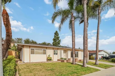 a front view of house with yard and trees around