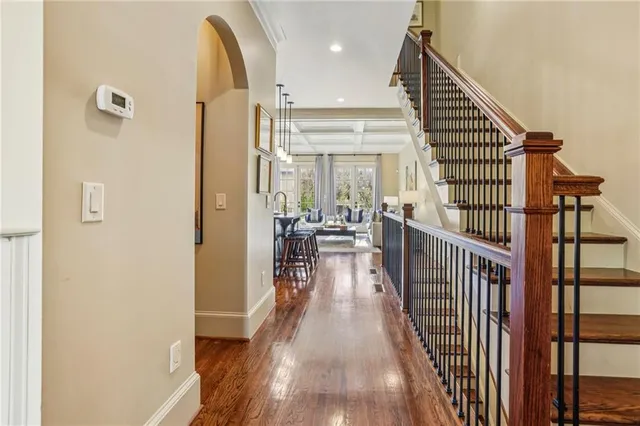 a view of a hallway with wooden floor and staircase