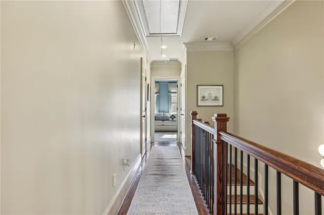 a view of a hallway with wooden floor and staircase