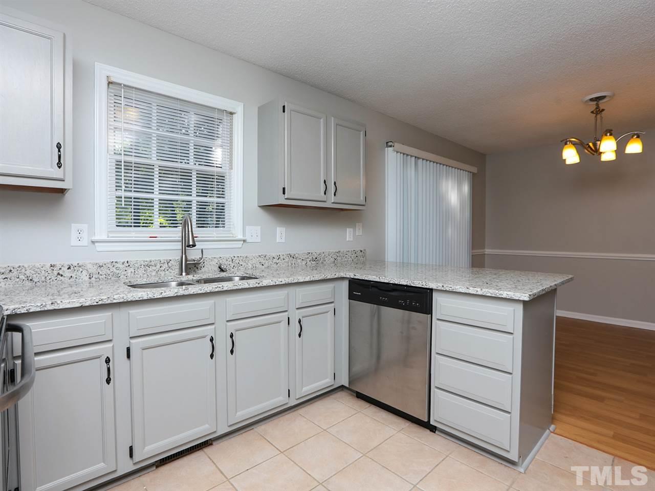 3537 East Jameson Road Raleigh, NC 27604 - Photo 4 of 17 a kitchen with granite countertop white cabinets and window